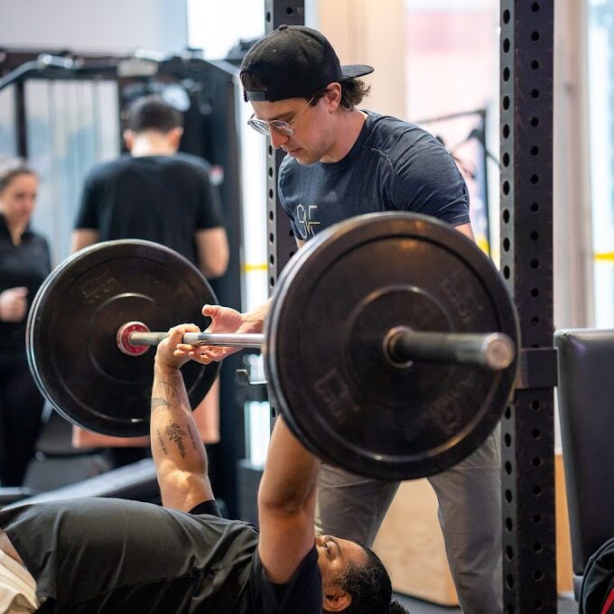 Coach Training Client on A Bench Press